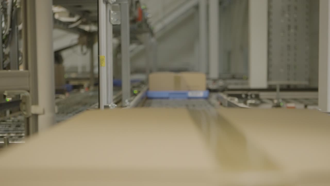 Package labeled "Medicamentos Muy Fragil" moves on an automated conveyor belt in a warehouse