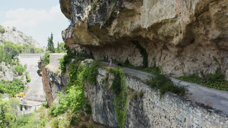 woman walking her dog on a scenic cliffside road