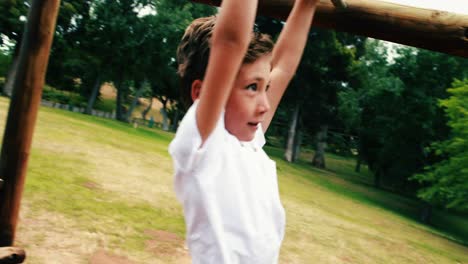 boy playing on a playground ride in park