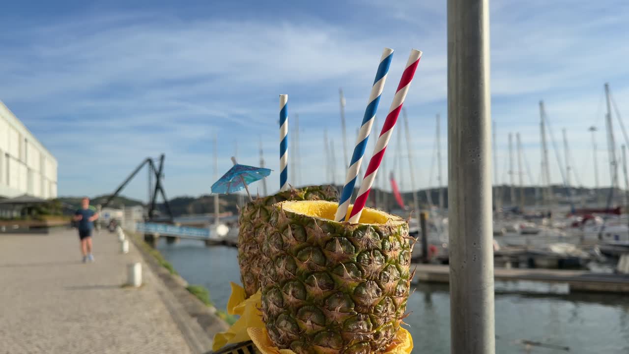Bevande rinfrescanti all'ananas con cannucce in una marina soleggiata