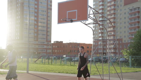 two men playing basketball outdoors