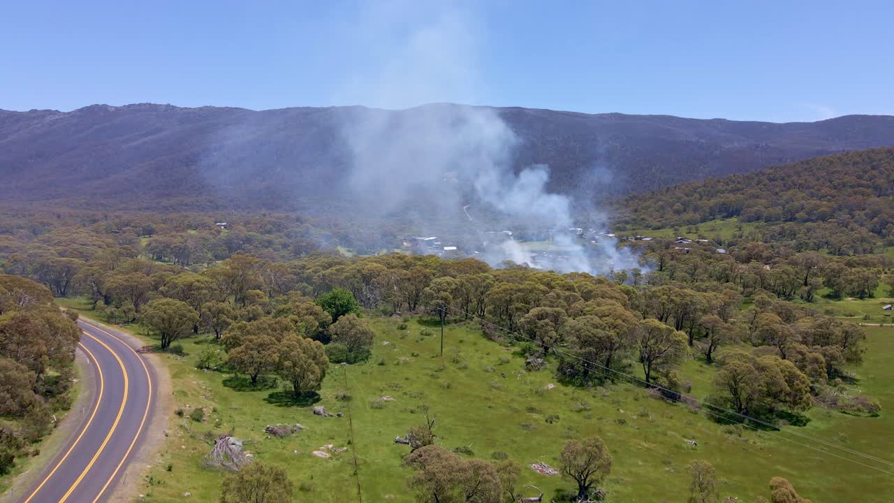vista aérea hacia adelante del humo que se extiende sobre el área de crackenback durante el día en nueva gales del sur, australia