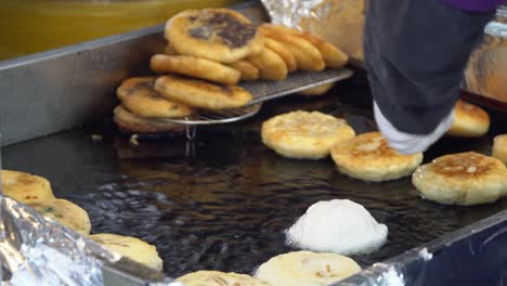 hands of a man cooking hotteok - korean pancake and popular street food in south korea