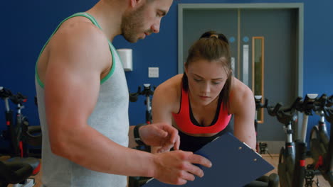 trainer with client on exercise bike