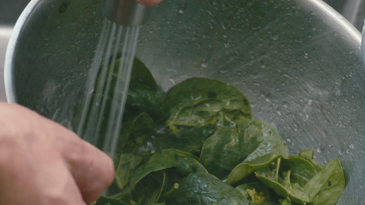 Washing Fresh Spinach Leaves In Metal Bow under Running Water