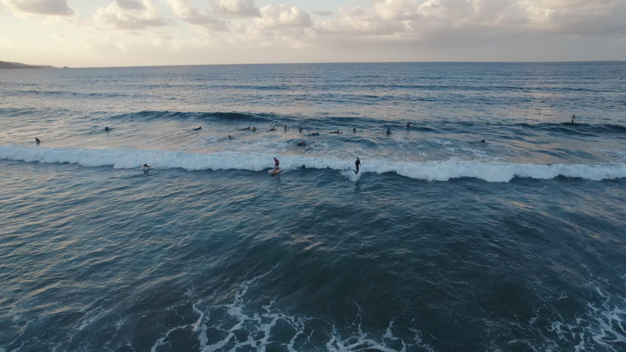 toma aérea cinematográfica en movimiento de surfistas en las olas en la playa de las canteras en las palmas de gran canaria, avión no tripulado