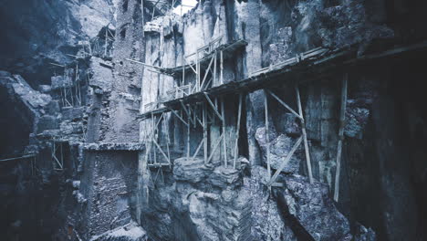 exploring the ancient cliffs and wooden structures in an abandoned quarry site