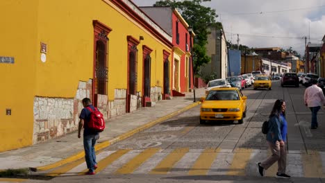 colorful street scene in a mexican city with yellow taxis