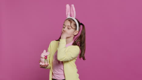 lovely little girl with bunny ears sending air kisses in studio