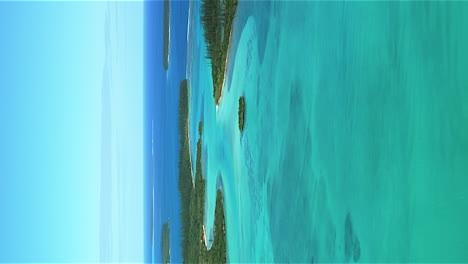 isle of pines new caledonia crystal clear water in a paradise lagoon - vertical aerial flyover
