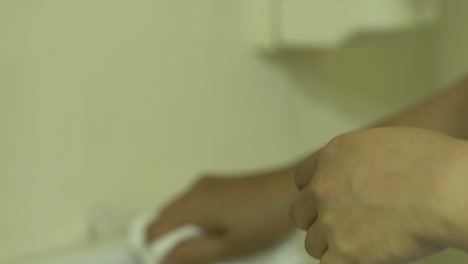 concepto de higiene, atención médica y seguridad: primer plano de una doctora o enfermera secándose las manos con papel tisú en el hospital