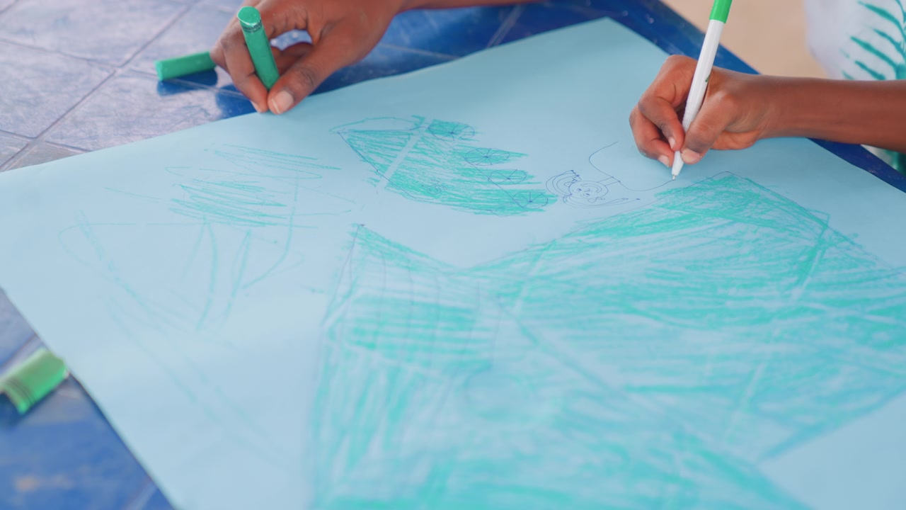 Guidance sparks artistic expression. Caregiving mother assists child in developing colorful paper shapes. Nurturing mother helps child craft lively drawings using bright hues and gentle guidance