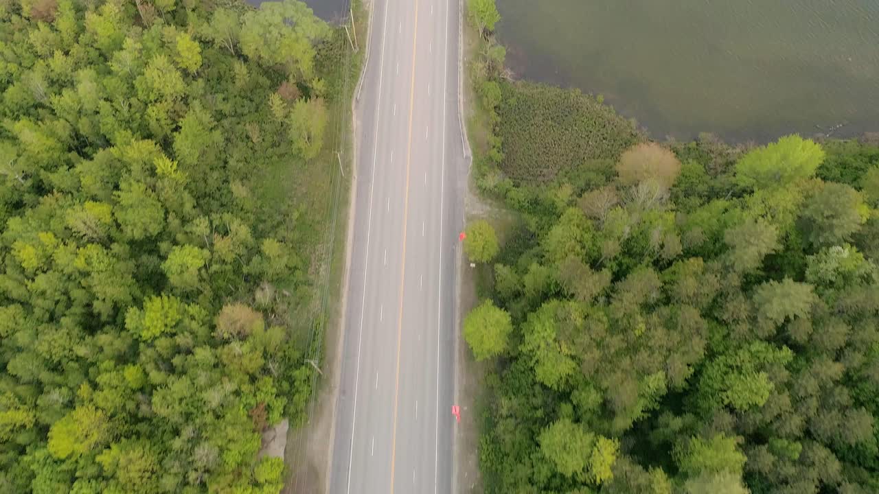 drone pasando por la carretera en un área forestal