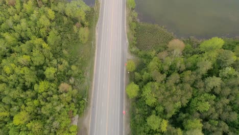 drone pasando por la carretera en un área forestal