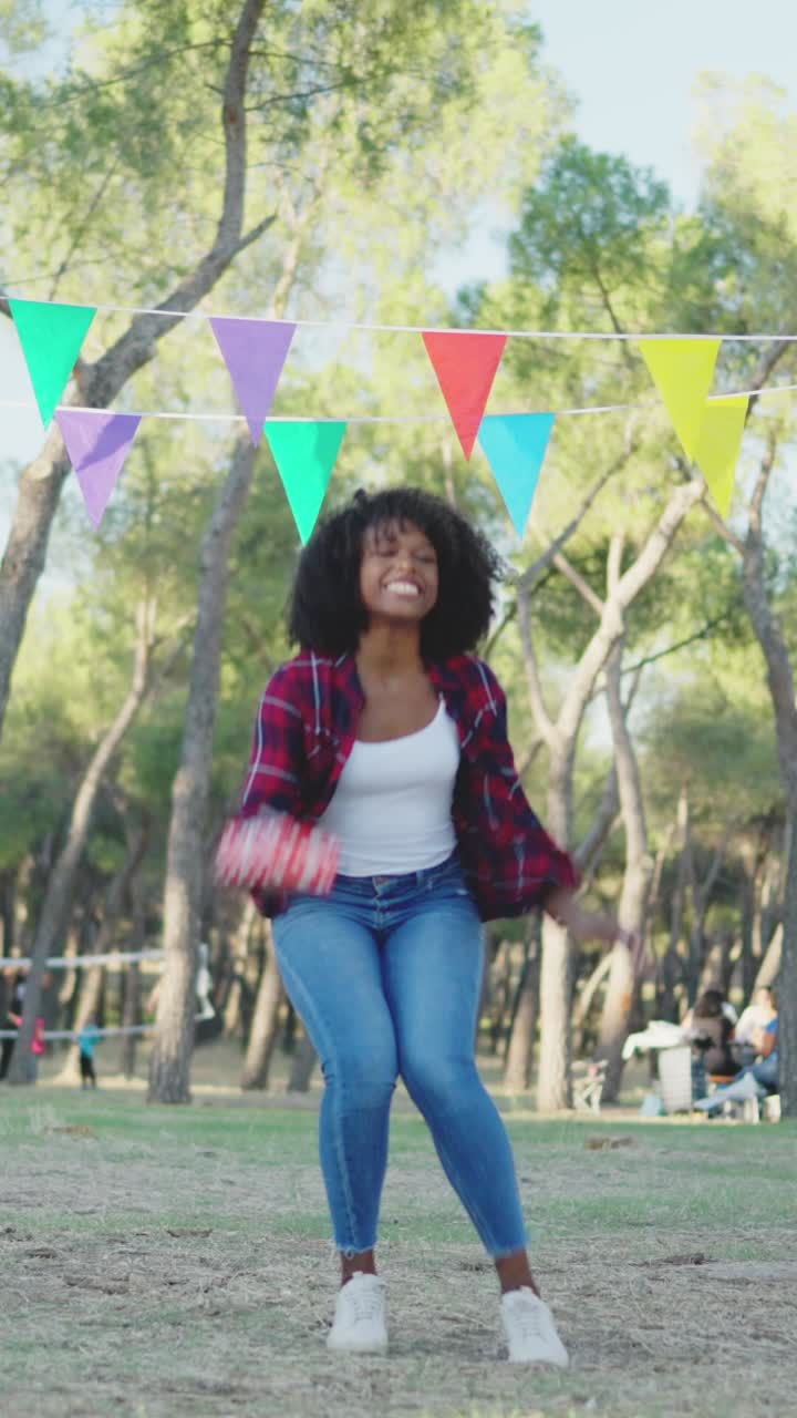 Joyful Young Woman Jumping and Dancing at an Outdoor Celebration