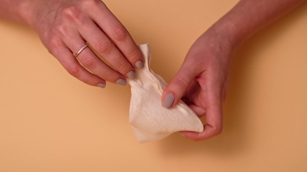 Woman hands removing a menstrual cup from a grocery eco purse