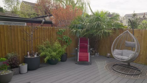 Minimalistic-UK-summer-garden-showing-swing-chair-decking-and-sun-lounger