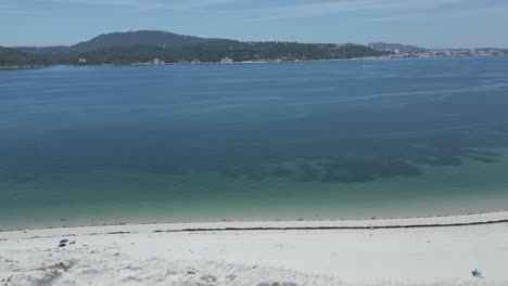 Aerial-view-of-a-tropical-paradise-beach-with-white-sand-and-clear-water-in-Nature-Park-Arrabida-in-Setubal,-Portugal