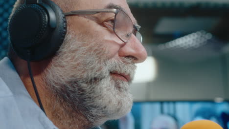 older man broadcasting in a studio