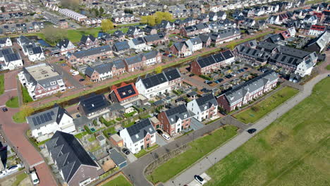 aerial of car driving through neighborhood with solar panels on rooftop