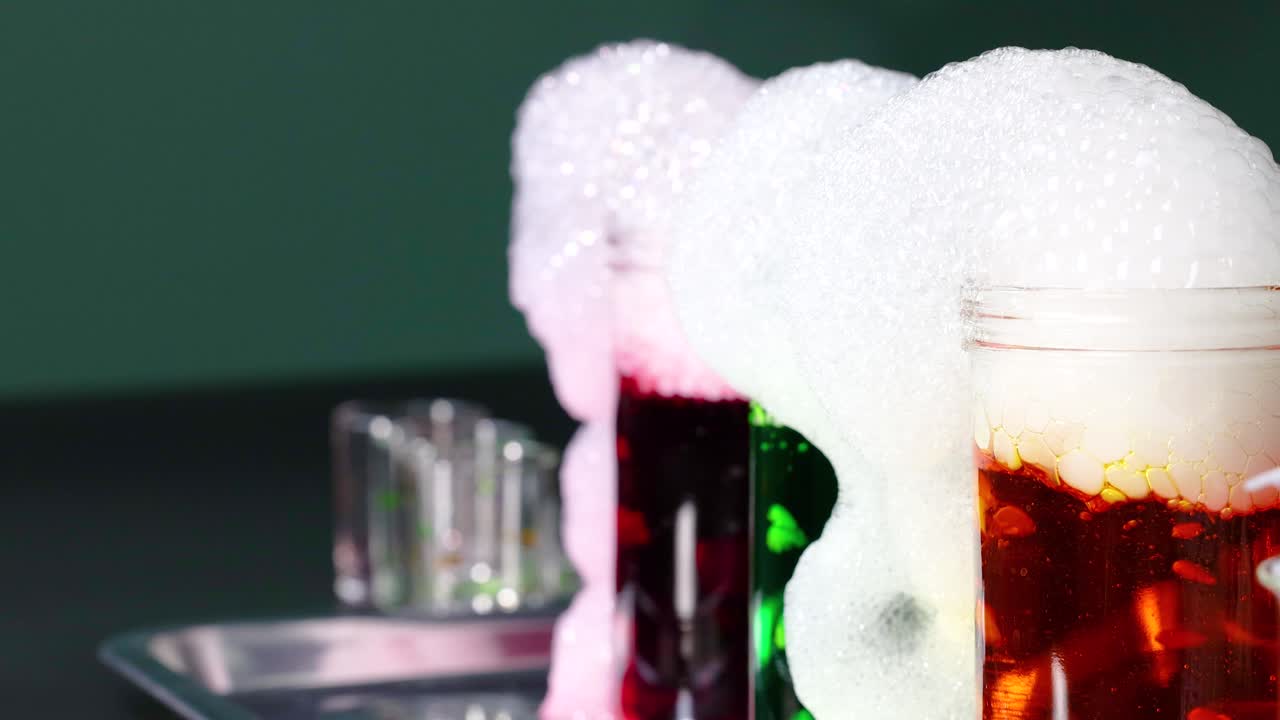 건조한 얼음으로 유리 용기에서 다채로운 거품 반응을 일으키는 생동감 넘치는 과학 실험