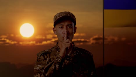 ukrainian soldier at sunset with finger on lips