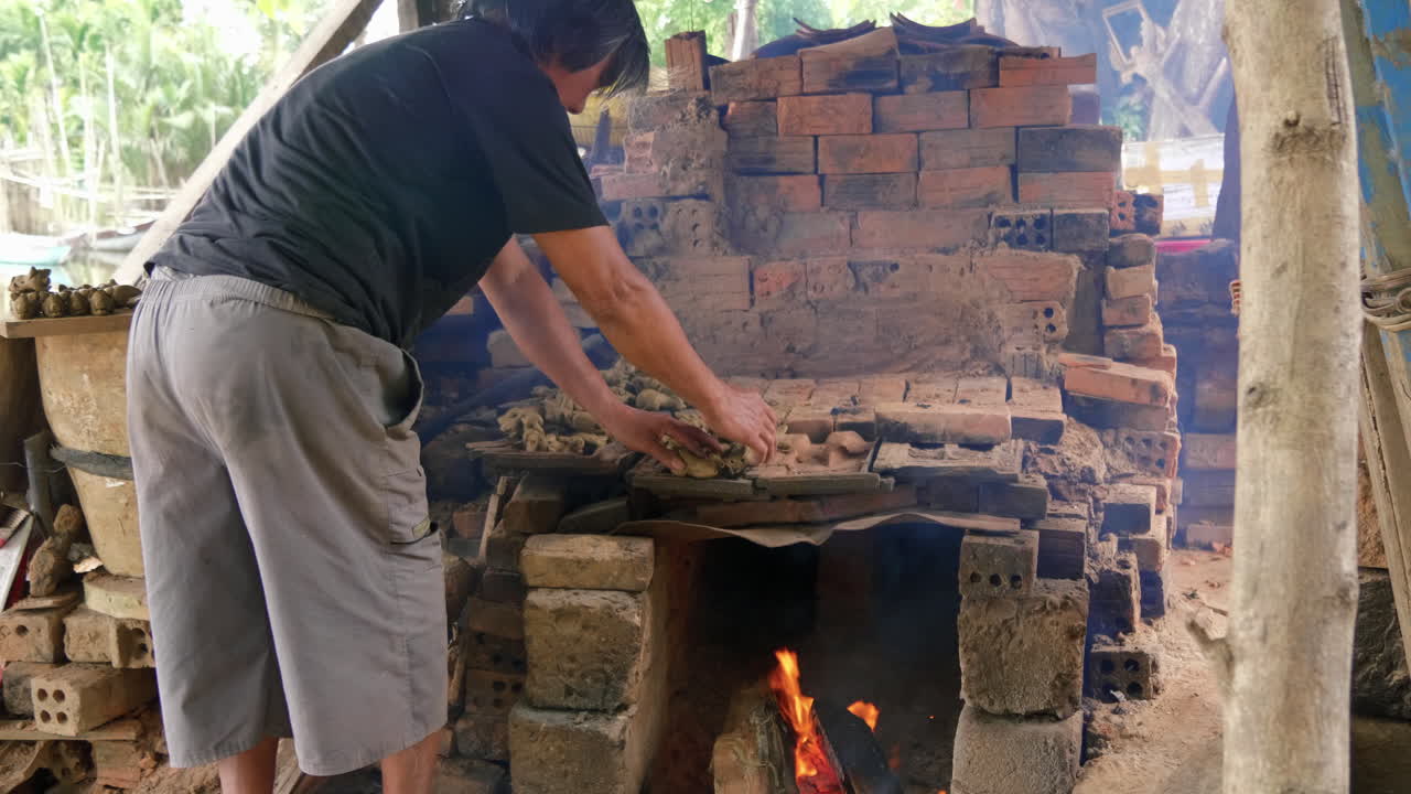 plano medio de alfarero colocando figuras de arcilla encima del fuego que ha hoi an vietnam