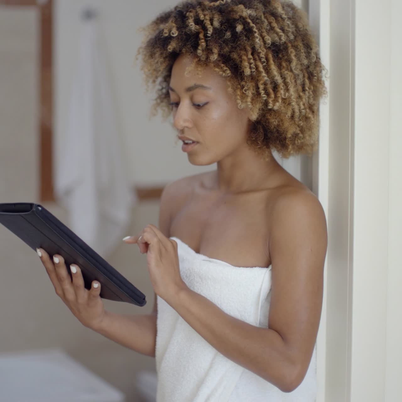 Woman Using Tablet Computer In Bathroom