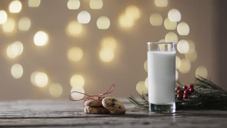 video of christma cookies, glass of miljk and copy space on wooden background