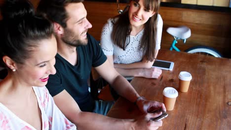 Man-and-women-sitting-in-restaurant-and-interacting-each-other