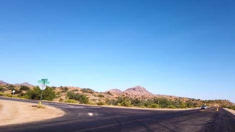 POV-driving-through-the-desert-on-a-lonely-highway-past-a-marked-lane-turn-off