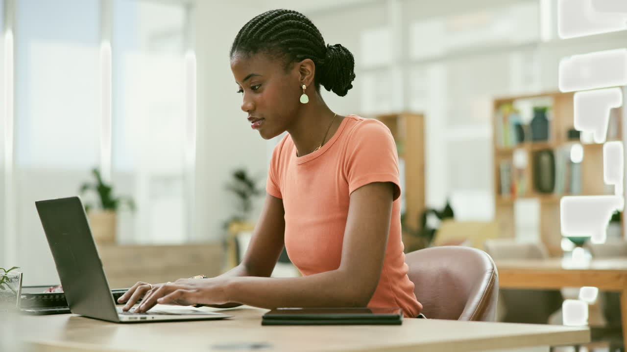 Woman working on laptop and tablet in modern office