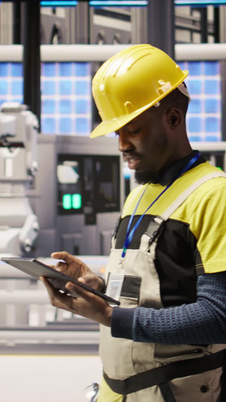Vertical video Technician in industrial plant using tablet app to diagnose equipment errors