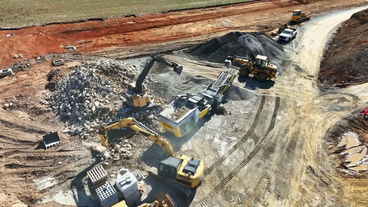 High-angle view of construction site with heavy machinery grinding concrete and stone for development rich detail vibrant colors dynamic movement smooth motion