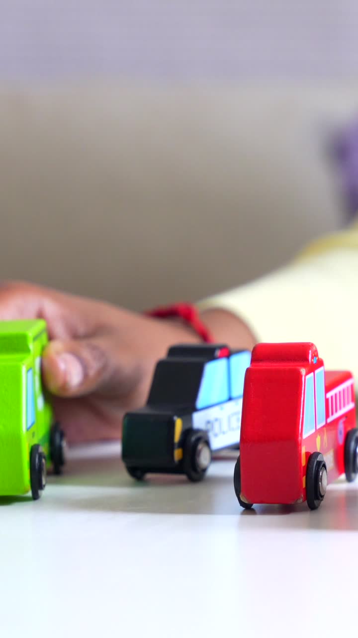 A close-up of colorful toy cars with a hand nearby