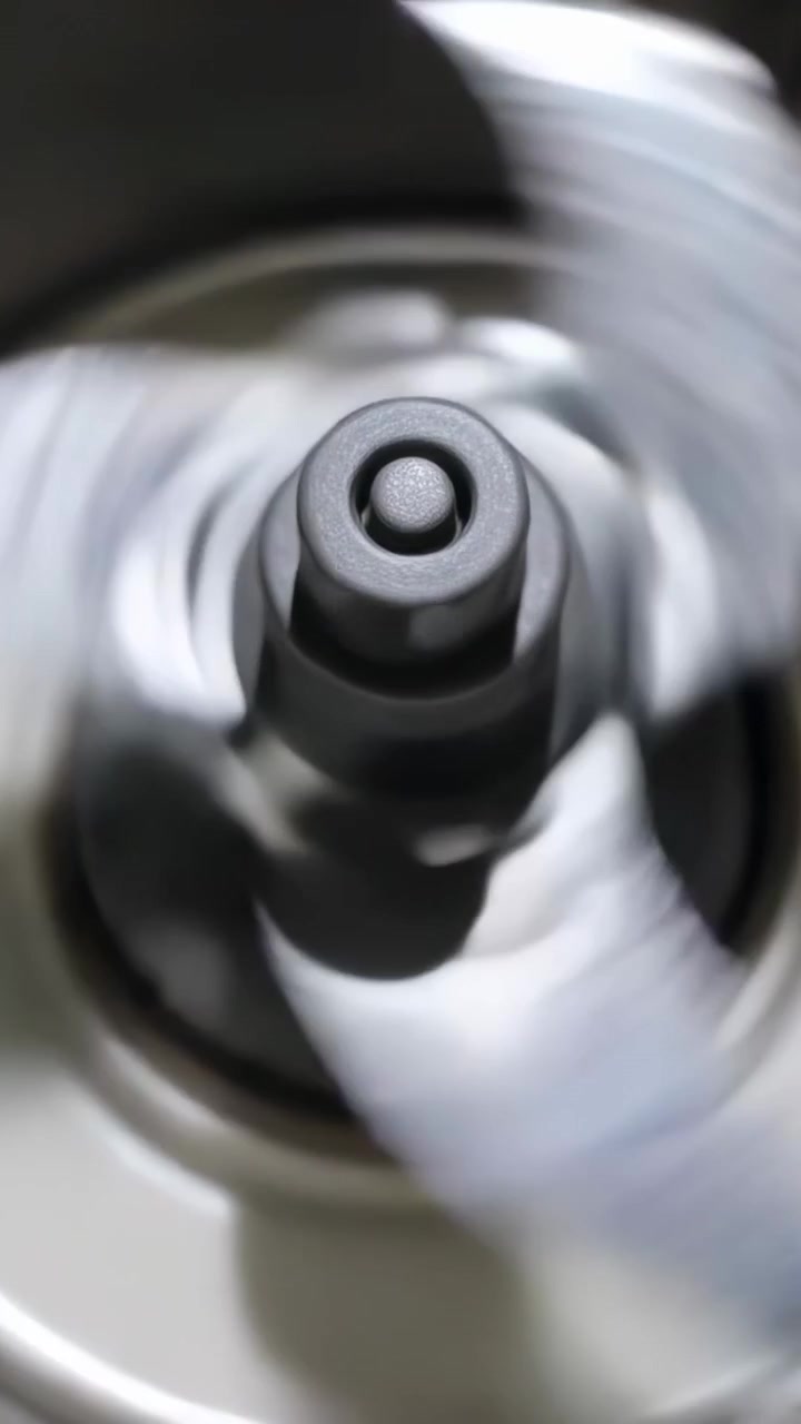Vídeo vertical: Motor ligando e girando um rotor de três pás sobre um balcão, exibindo o cubo e a borda do recipiente para operação.