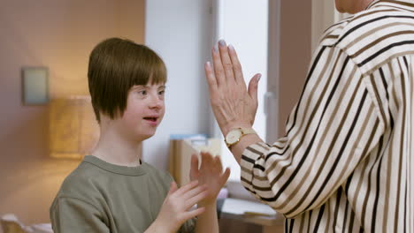 adolescente sonriente jugando en casa con su madre