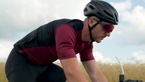 road cycling - cyclist riding a road bicycle along the fields with crops