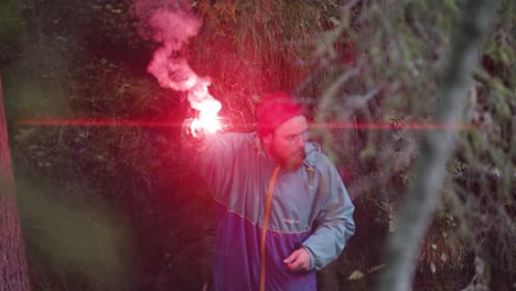 man with red flare in the woods