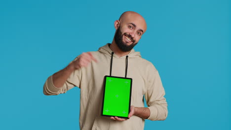persona musulmana sosteniendo una tableta con una plantilla de pantalla verde