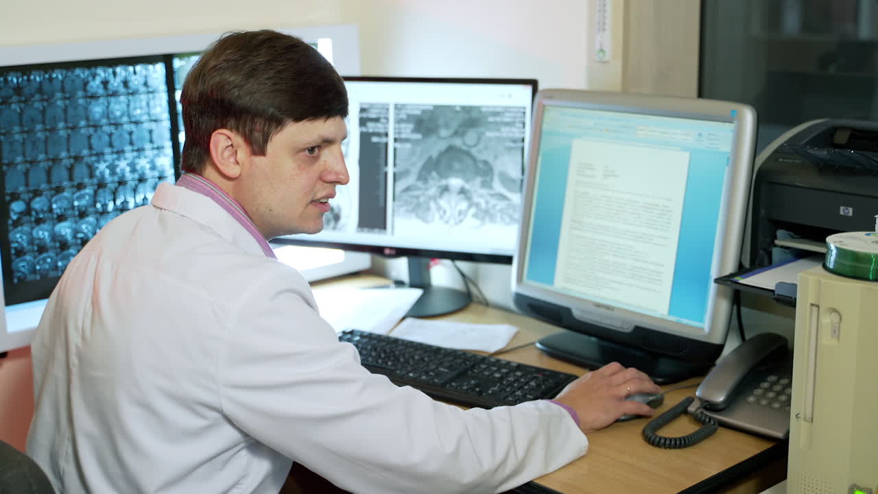 Doctor looking at computer screen. Rear view of doctor in modern hospital looking at computer