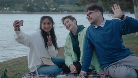 college friends taking a selfie in the park