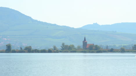 view of a church lying in the middle of a flooded lake all over the surrounding area