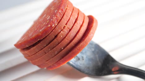 salame en rodajas en un tenedor