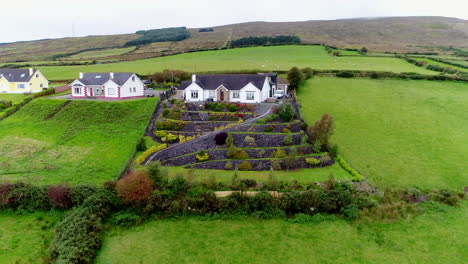 drone shot of houses surrounded by the lush green fields of donegal, ireland