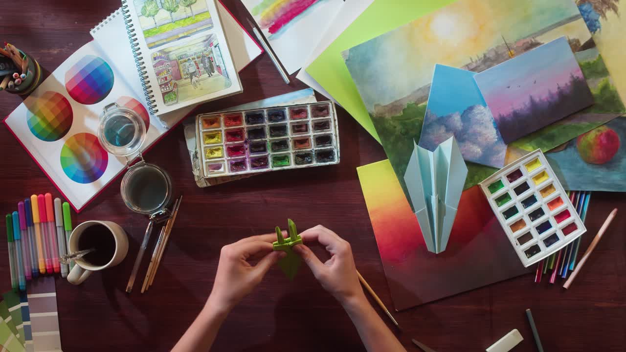 Top View of Hands Folding Origami on a Creative Art Desk