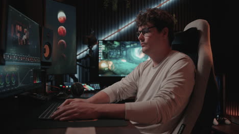man working on a computer in a dark room
