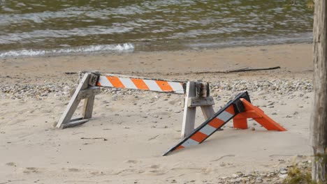 aumento del nivel del mar que causa erosión, arena de playa que cubre la valla de barricada