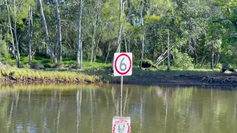 escena del río tranquilo con señal de límite de velocidad