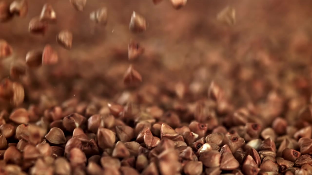 Grani di grano saraceno crudo che cadono e si accumulano